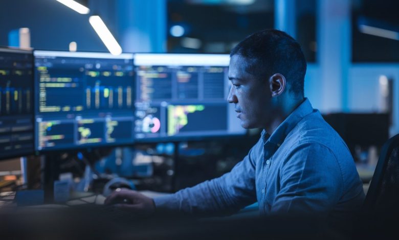 Un expert en cybersécurité analyse des données sur plusieurs écrans